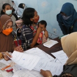 Ibu dari salah satu anak penerima bantuan dari Kemensos, Yuni, saat dilayani petugas Dinsos Kota Kediri. Foto: Ist