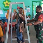 Babinsa Koramil 0827/01 Kota Sumenep, Kopka Taufik, yang didampingi bidan desa saat giat Posyandu.