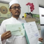 Direktur PT Sabrina Laksana Abadi H. Achmad Miftach Kurniawan saat menunjukan kwitansi pembayaran dan bukti laporan dari Polresta Sidoarjo.