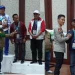 Ketua PWI Jatim Lutfil Hakim (foto kiri) saat menyerahkan medali kepada para peraih medali.