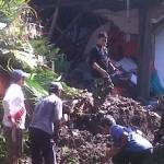 Warga dan petugas dari BPBD Lumajang sedang bergotong royong membersihkan puing-puing longsoran. foto: imron/BANGSAONLINE