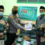 Kapolres Kediri Kota AKBP Wahyudi saat menyerahkan bantuan secara simbolis kepada Ketua PCNU Kota Kediri KH. Abu Bakar Abdul Jalil. foto: ist.