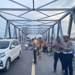 Personel Satlantas Polres Probolinggo saat mengatur kendaraan yang melewati Jembatan Pajarakan yang tengah diperbaiki