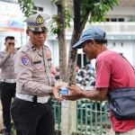 Kanit Kamsel Satlantas Polres Gresik, Ipda Andreas Dwi Anggoro, saat berbagi makanan kepada warga. Foto: Ist. 