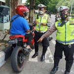 Petugas Satlantas Polres Gresik saat menindak pengendara bermotor yang menggunakan knalpot brong. foto: SYUHUD/ BANGSAONLINE