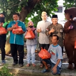 Ketua IWNU Gresik, Sunyoto, bersama pengurus saat memberikan bantuan paket sembako. Foto: SYUHUD/BANGSAONLINE