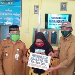 Camat Tambak Pulau Bawean Kabupaten Gresik, Agung  Endro DS saat menyerahkan BLT DD secara simbolis kepada warga. (foto: ist).