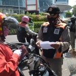 Petugas berjaga di pos penyekatan Bundaran Waru untuk memeriksa kendaraan dari luar Surabaya, Sabtu (22/5/2021).