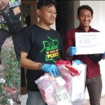 Petugas menunjukkan kondom yang ditemukan berserakan di sekitar rumah. Foto kanan, petugas menunjukkan sejumlah barang bukti yang diamankan.