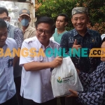 Direktur Utama Petrokimia Gresik, Dwi Satriyo Annurogo, didampingi Direktur Keuangan dan Umum, Budi Wahju Soesilo, saat menyerahkan paket bantuan kepada warga. Foto: SYUHUD/ BANGSAONLINE