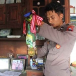 Bripda Andrian Setiyoso, seorang polisi sekaligus seorang atlet wushu saat menunjukkan medali yang pernah diraihnya. Foto: Ist.