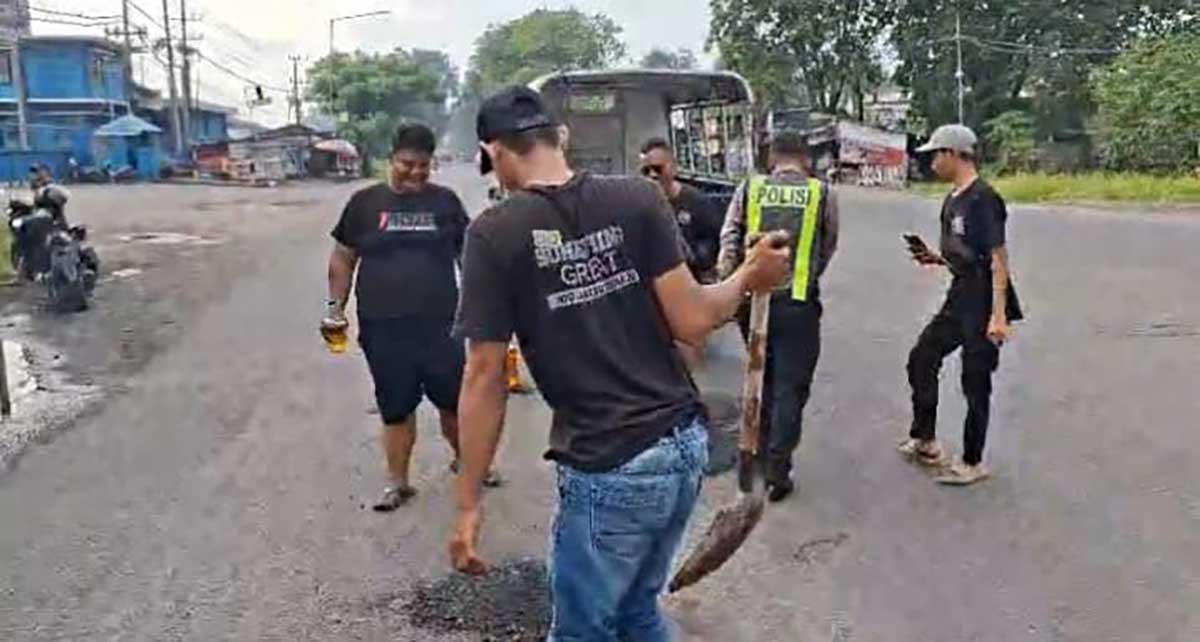 Petugas dari Polsek Krian saat menutup jalan berlubang.