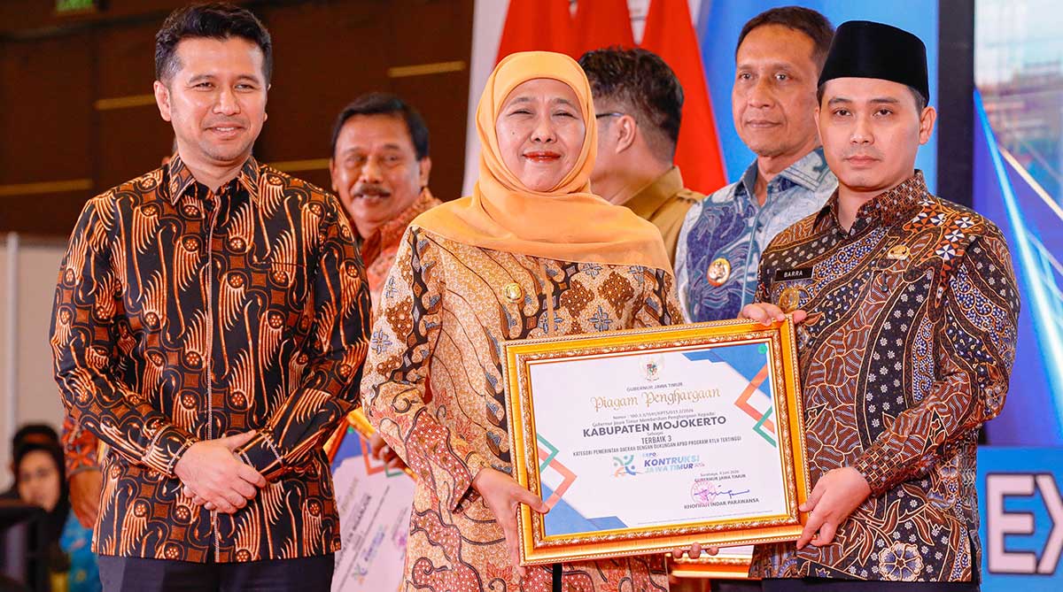 Bupati Mojokerto ketika menerima penghargaan untuk program Rutilahu dari Gubernur Khofifah.