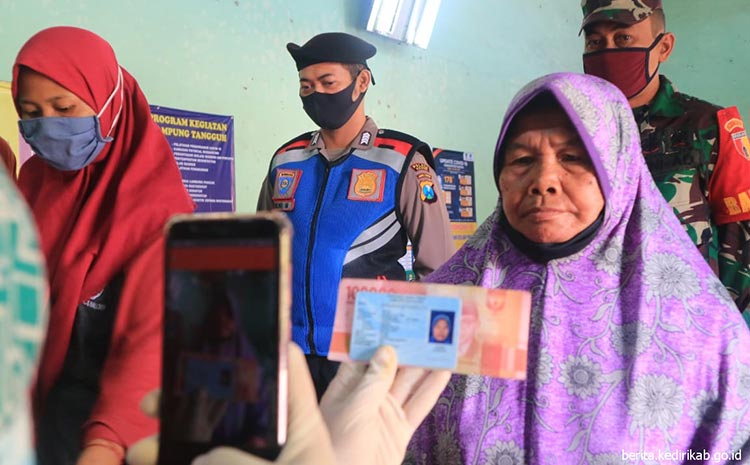 Peneriman BST tahap VII saat difoto oleh petugas, kemudian uang tunai Rp 300 ribu diserahkan.
