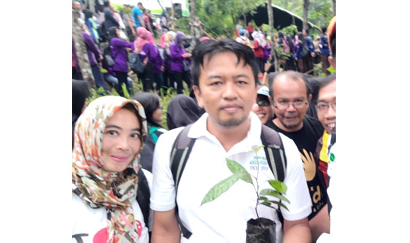 Budiman (pegang bibit pohon) dan para pegiat lingkungan saat aksi tanam pohon di lembah Tretes, lereng Wilis. foto: MUJI HARJITA/ BANGSAONLINE