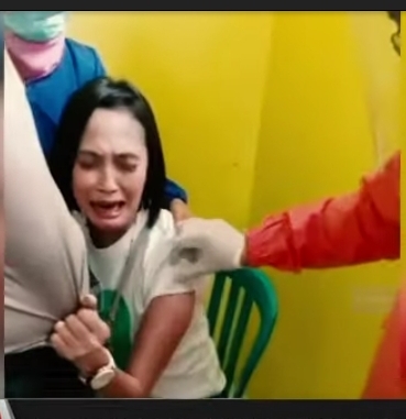 Ekspresi wajah Aiptu Fitria Wati saat menangis dan menjerit-jerit histeris saat mau disuntik vaksin di Puskesmas Kajayan Pasuruan Jawa Timur.