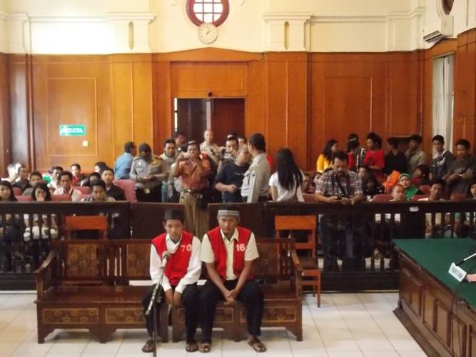 Dua terdakwa sesaat sebelum menjalani sidang pengeroyokan sesama Bonek, Senin (10/3/2014). foto:faishal/BANGSA ONLINE