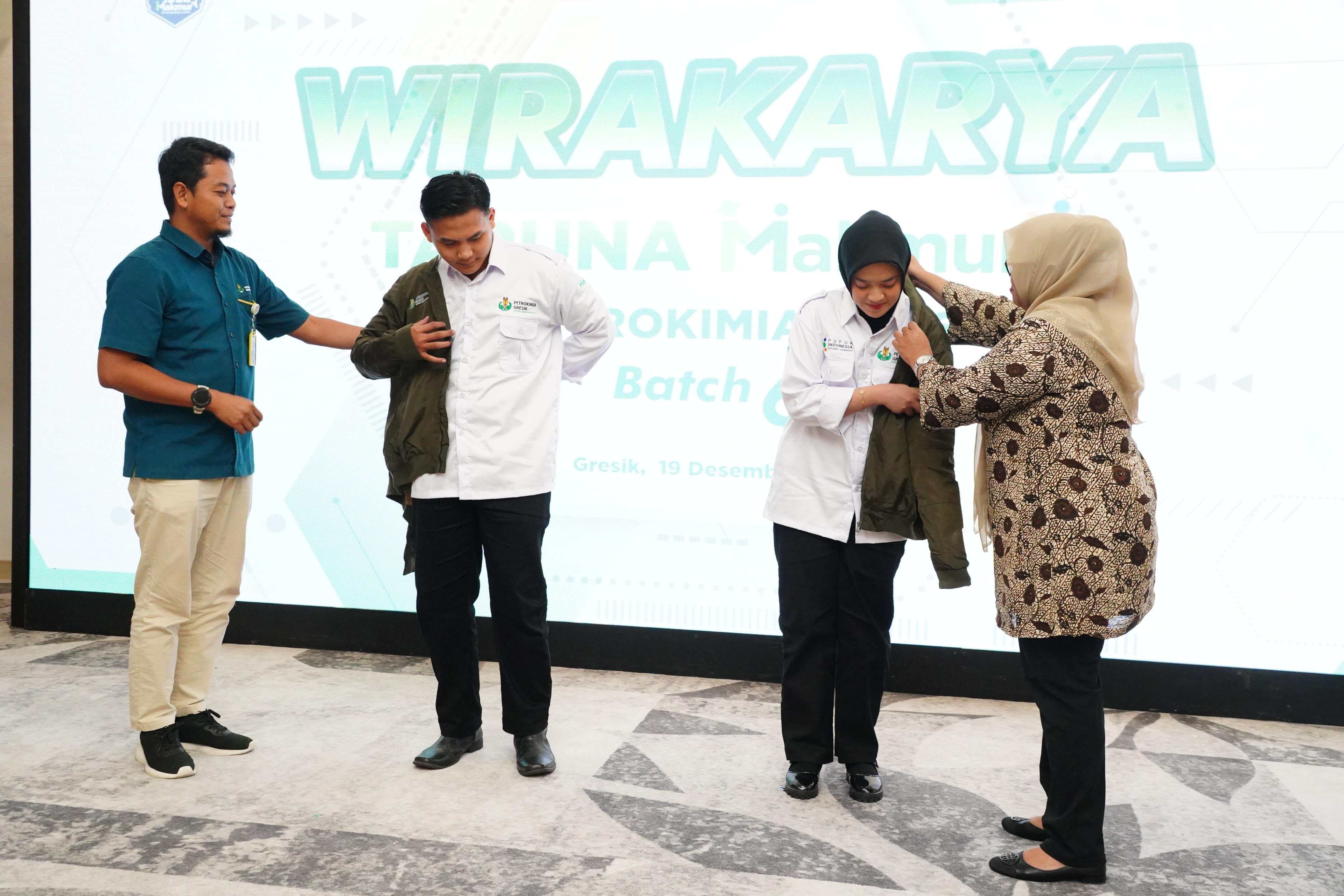 VP Pengelolaan Transformasi Bisnis Petrokimia Gresik Grastayana Suki (kiri) memakaikan jaket kepada Taruna Makmur saat akan diberangkatkan ke berbagi daerah. Foto: ist.