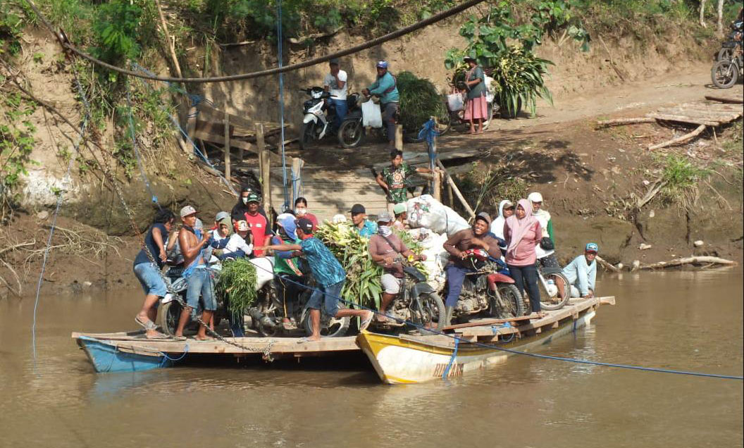 Warga Dusun Brogoh dan Dusun Ungkalan saat menyeberangi Sungai Mayang menggunakan rakit.