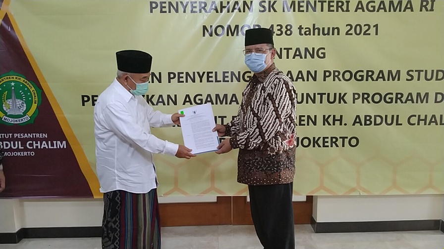 Prof Dr Suyitno, MAg, Dirjen Pendidikan Tinggi Keagamaan Islam Direktorat Jenderal Pendidikan Kementerian Agama menyerahkan SK ijin penyelenggaraan program studi pendidikan agama Islam untuk program doktor pada IKHAC yang diterima Prof Dr KH Asep Saifuddin Chalim, MA , di PP Amanatul Ummah Surabaya,Selasa (4/5/2021). Foto: mma/bangsaonline.com