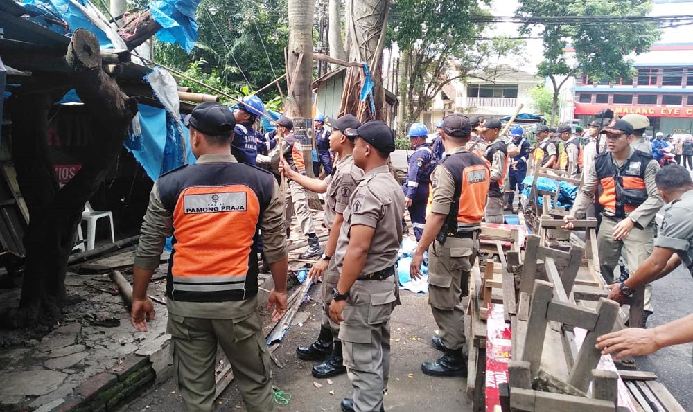 Tim Gabungan Satpol PP, TNI, dan Polri saat menertibkan warung di Jalan Diponegoro, Klojen, Kota Malang, Rabu (26/02). foto: IWAN IRAWAN/ BANGSAONLINE