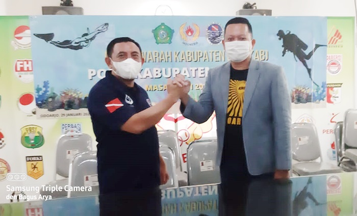 Bambang Pujianto (kiri) bersalaman dengan M Ridho Prasetyo, usai terpilih aklamasi sebagai Ketua POSSI Sidoarjo.