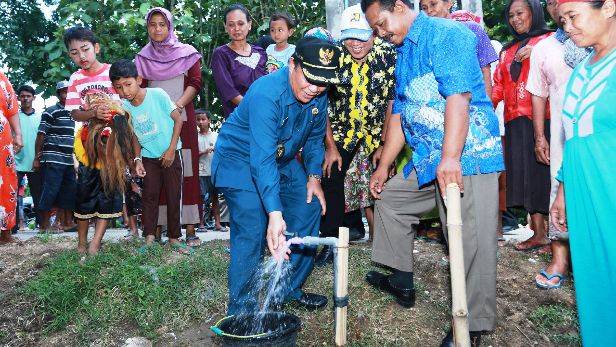 Bupati Fadeli mencoba air bersih yang dibangun. (Haris/BangsaOnline)