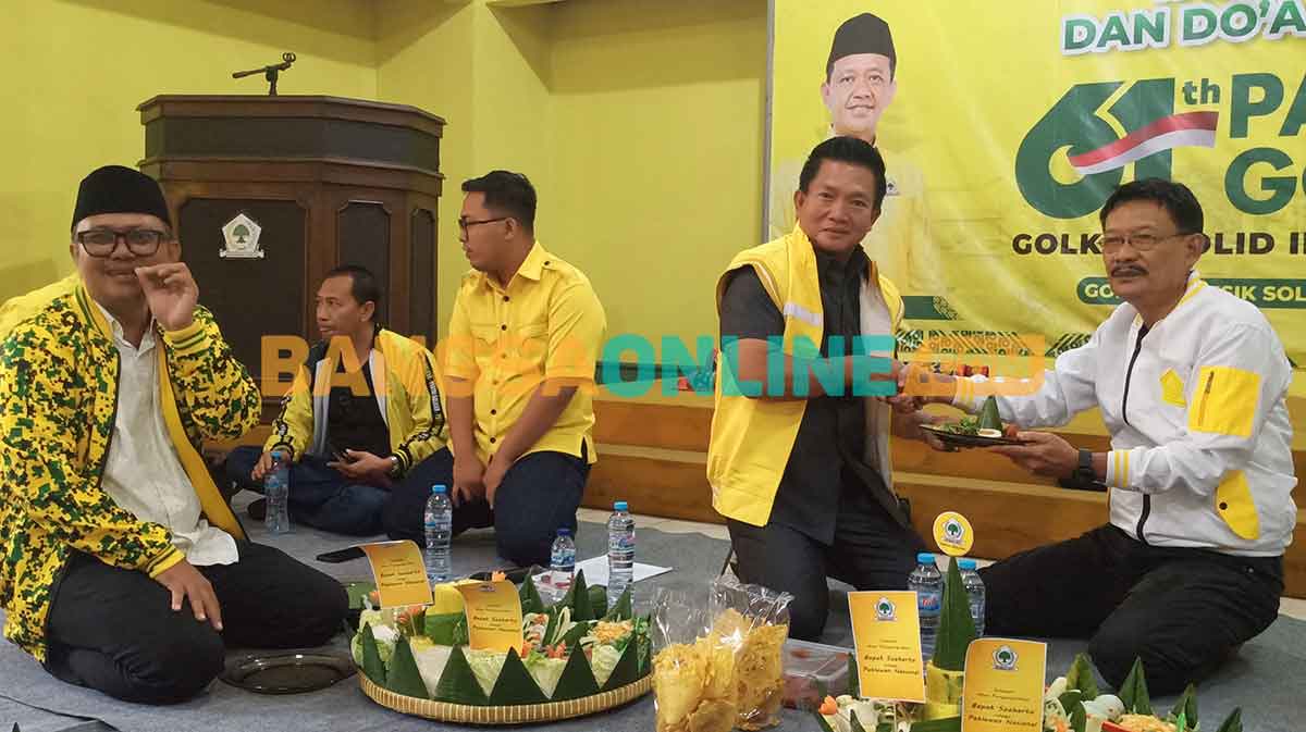 Ketua DPD Golkar Gresik, Wongso Negoro, saat menyerahkan potongan tumpeng kepada Ketua Fraksi Golkar DPRD Gresik, Atek Ridwan, dalam tasyakuran penobatan gelar pahlawan nasional Soeharto. Foto: SYUHUD/BANGSAONLINE