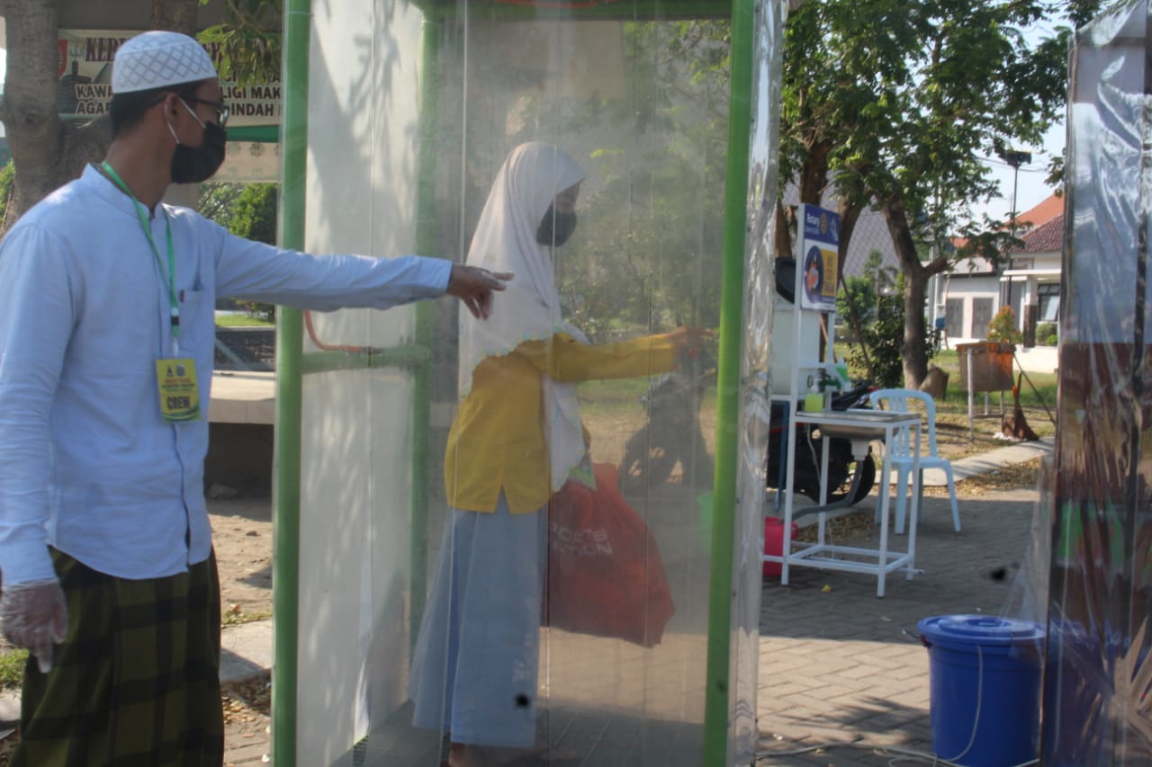 Salah satu santri Pesantren Tebuireng memasuki water scanner sebelum memasuki areal pesantren. foto: ist/ bangsaonline.com