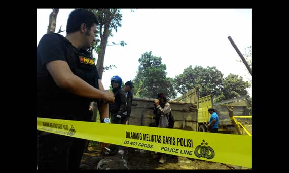 Petugas kepolisian saat memasang garis polisi di lokasi tambang ilegal. foto: arif kurniawan/BANGSAONLINE