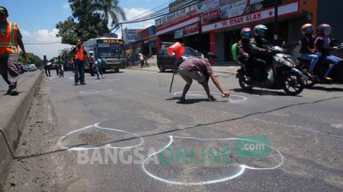 BIKIN KECELAKAAN: Komunitas Peduli Jombang saat aksi memberi tanda pada jalan berlubang. foto: rony suhartomo/ BANGSAONLINE
