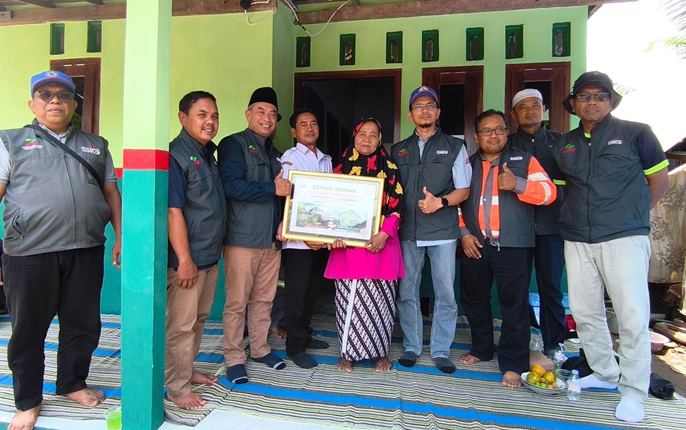 Sekretaris UPZ SIG Pabrik Tuban, Andik Sutikno, bersama tim saat serah terima rumah layak huni untuk Sarpuah, warga Desa Kapu, Kecamatan Merakurak.