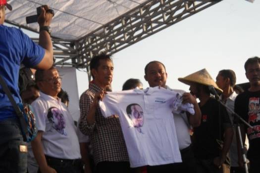 KAOS DUKUNGAN – Elemen ‘Orangnya Sutrisno Bachir’ menyerahkan kaos bergambar Jokowi warna biru kepada capres Joko Widodo (Jokowi) di tanggul lumpur titik 21 di Desa Siring Kecamatan Porong Sidoarjo, Kamis (29/5). foto : mustain/BangsaOnline