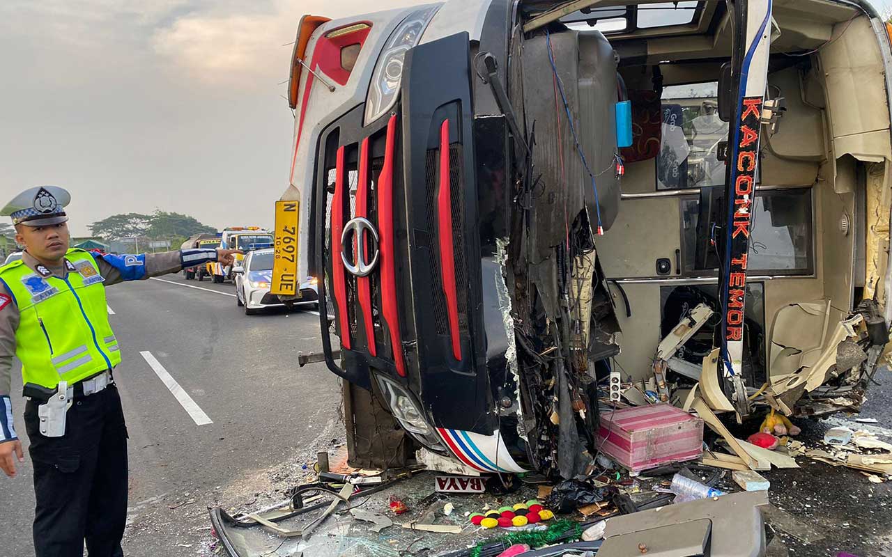 Anggota PJR Ditlantas Polda Jatim saat menunjukkan kondisi Bus Tentrem usai alami kecelakaan di Jalan Tol Sidoarjo-Porong, Senin (4/12/2023).