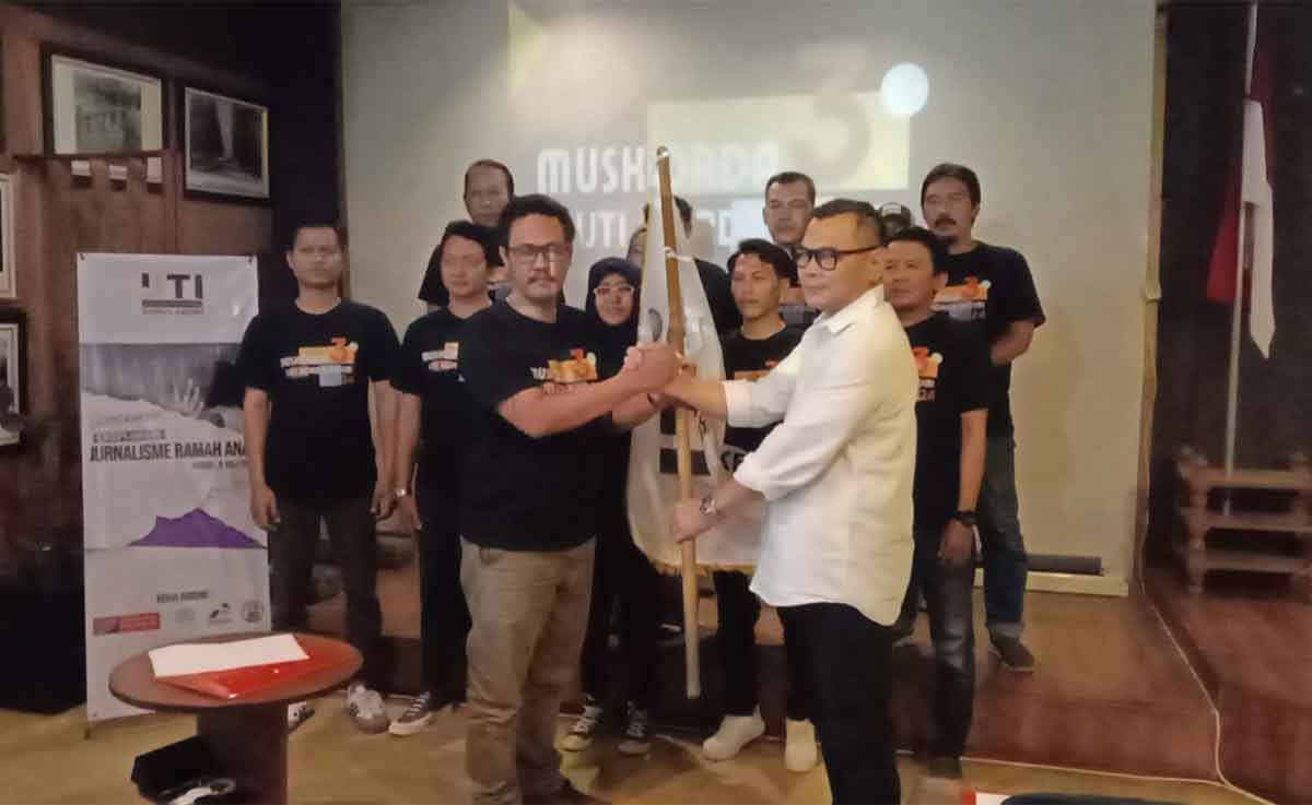 Ketua IJTI Korda Kediri periode 2024-2027, Roma Duwi Juliandi, saat menerima bendera dari Ketua IJTI Pengda Jatim, Ahmad Willyanto. Foto: Ist