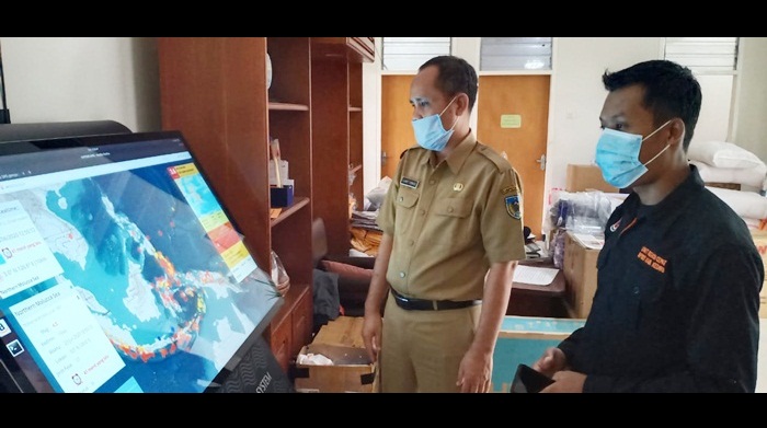 Plt. Kepala BPBD Kabupaten Kediri Slamet Turmudzi (kiri) dan stafnya, sedang mengamati monitor WRC. 
