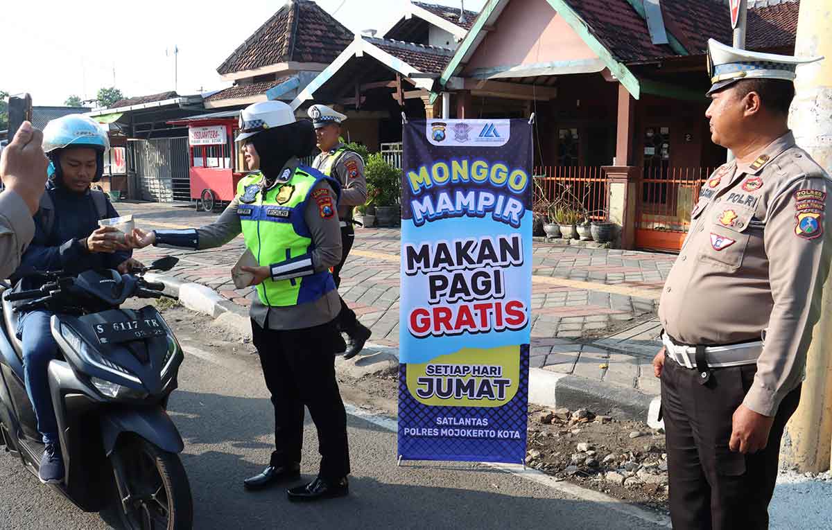 Petugas dari Satlantas Polres Mojokerto Kota saat membagikan makan gratis ke pengguna jalan.