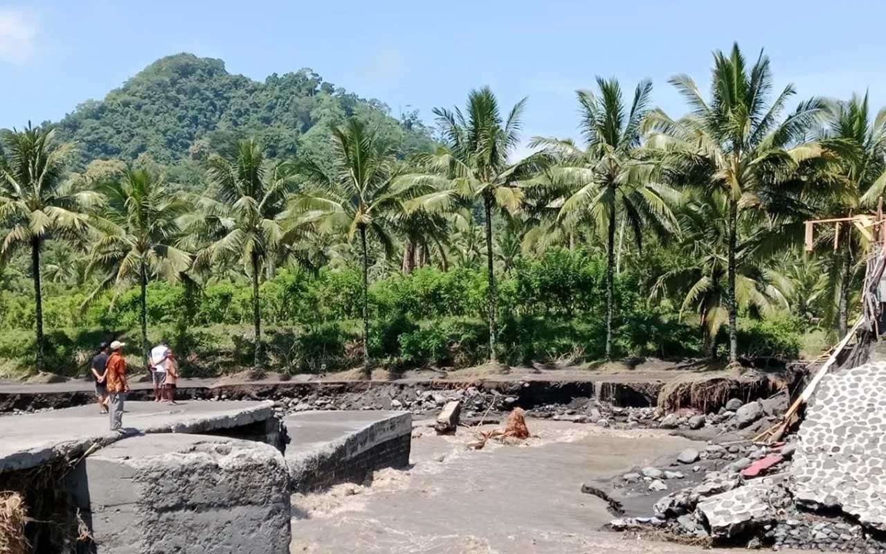 Sejumlah warga melihat Jembatan Gondoruso di Kecamatan Pasirian yang terputus akibat banjir lahar dingin Gunung Semeru pada Jumat (19/4/2024).