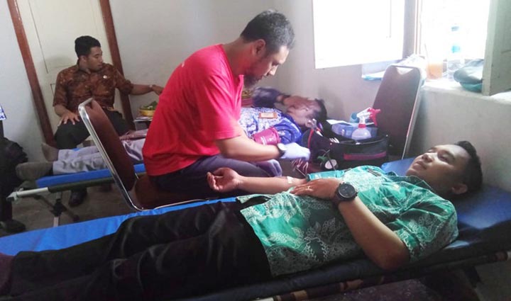 Petugas medis sedang menangani seorang pendonor.