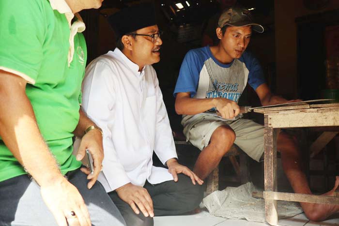 Gus Ipul dengan serius memperhatikan seorang pengrajin keripik tempe yang sedang bekerja.  
