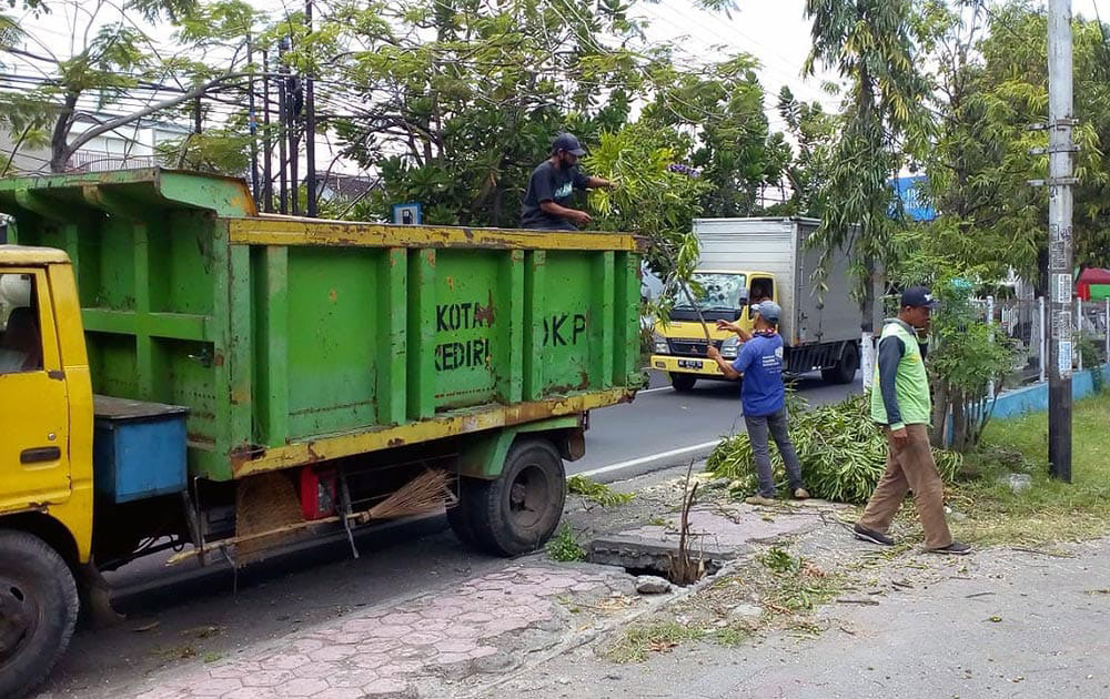 Petugas saat memotong pohon tumbang dan menaikkan ke truk untuk dibuang. foto: ist.