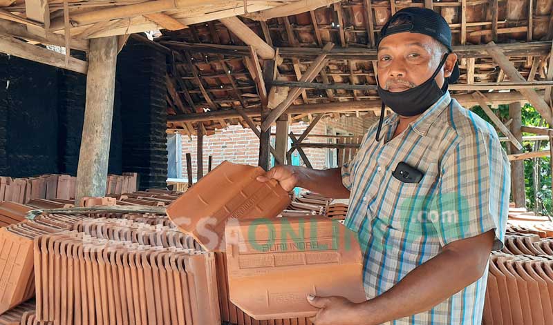 Yulianto saat menunjukan genteng yang siap jual.