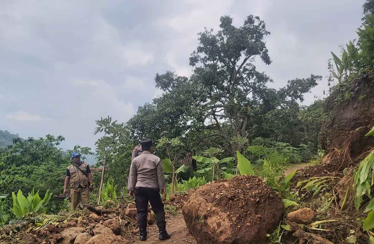 Kamid selaku Kepala Dusun Kajar, Desa Kalipang, Kecamatan Grogol, Kabupaten Kediri, bersama aparat kepolisian saat mengecek lokasi longsor. Foto: Ist