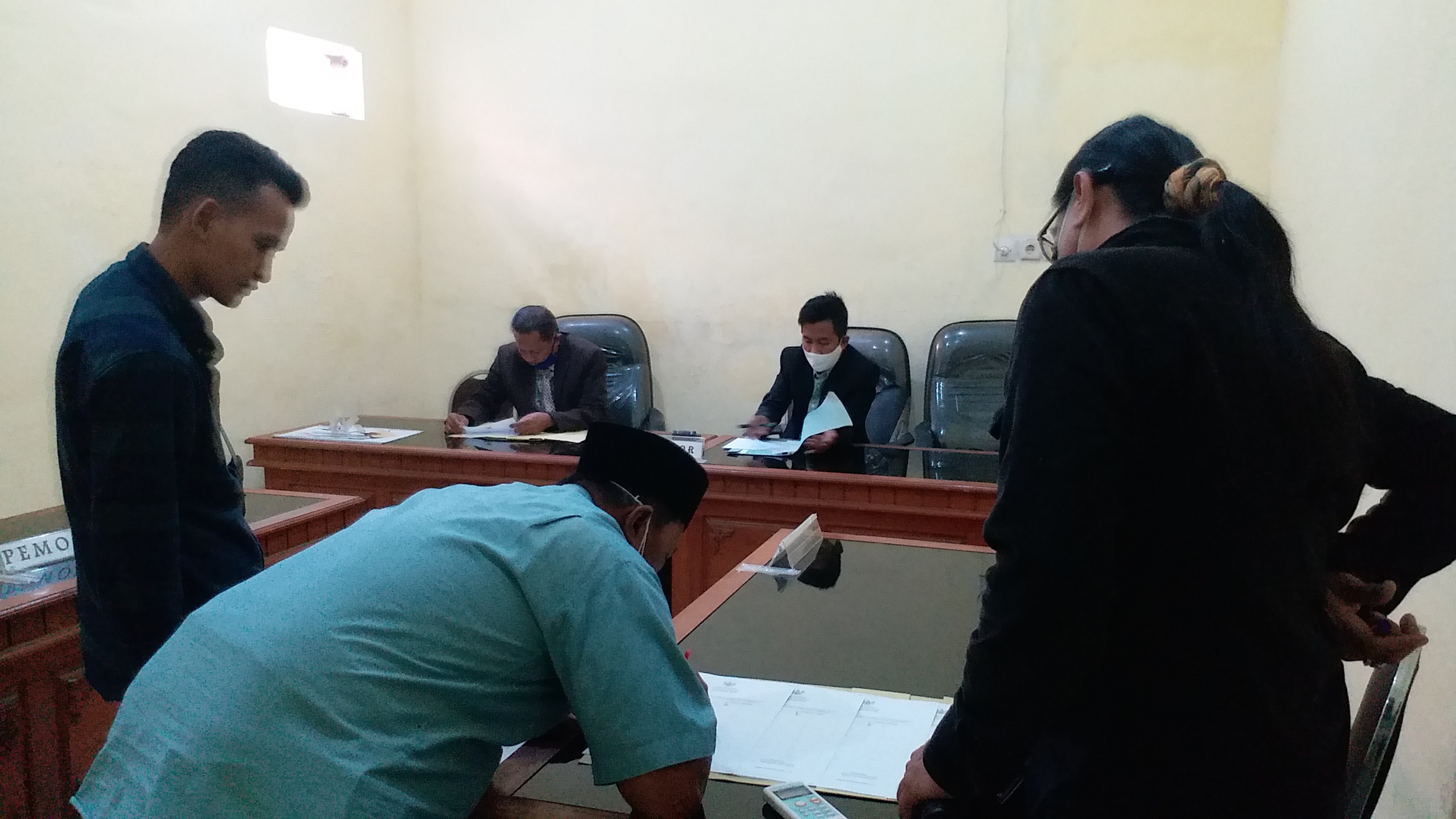 Risang BW, Kuasa Hukum Termohon dan Rohman, Kuasa Hukum Pemohon saat mengisi daftar buku hadir sebelum sidang sengketa di Komisi Informasi Bangkalan, Rabu (8/7).