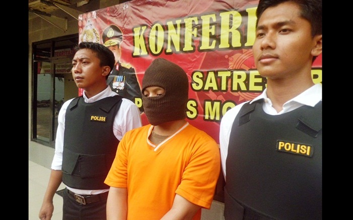 Pelaku sedang diapit petugas. Foto: SOFFAN S/BANGSAONLINE