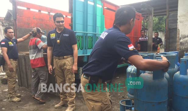 Petugas kepolisian dari Polres Kediri Kota saat mengangkut tabung gas elpiji untuk diamankan. foto: arif kurniawan/ BANGSAONLINE