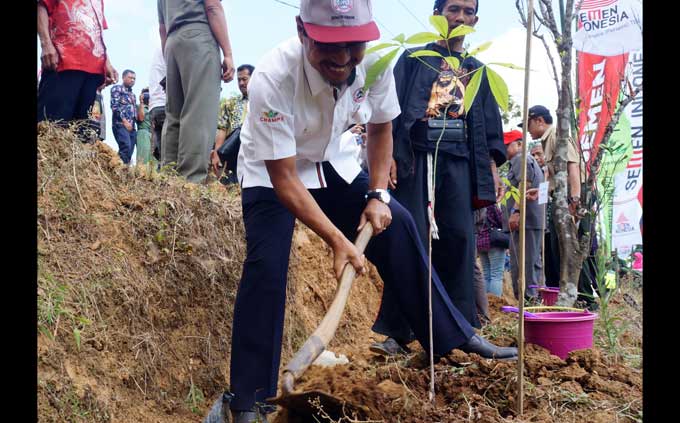 Direktur Utama Semen Gresik Gatot Kustyadji melakukan penanaman karet di daerah rawan longsor yang berada di Desa Bengkering, Kecamatan Pulung, Kabupaten Ponorogo. foto: SYUHUD/ BANGSAONLINE
