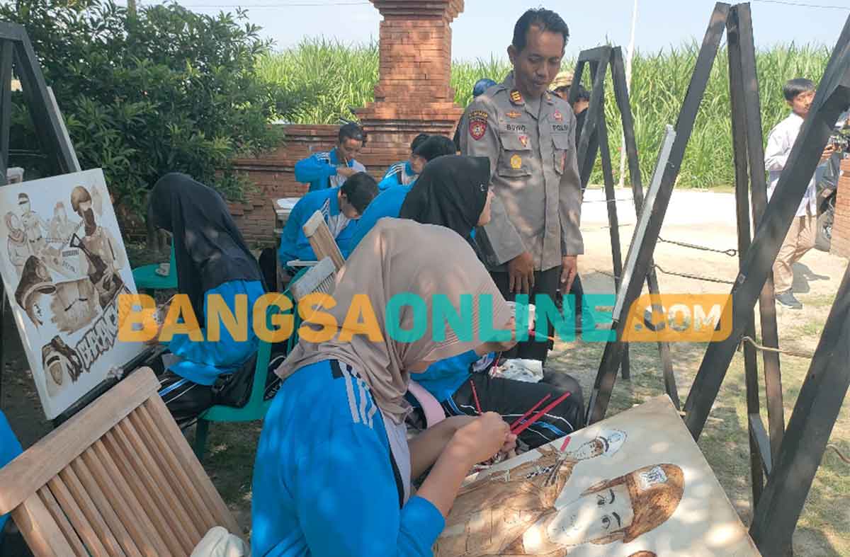 Kapolsek Plemahan, AKP Bowo Wicaksono, saat mengamati lukisan para pelajar. Foto: MUJI HARJITA/BANGSAONLINE