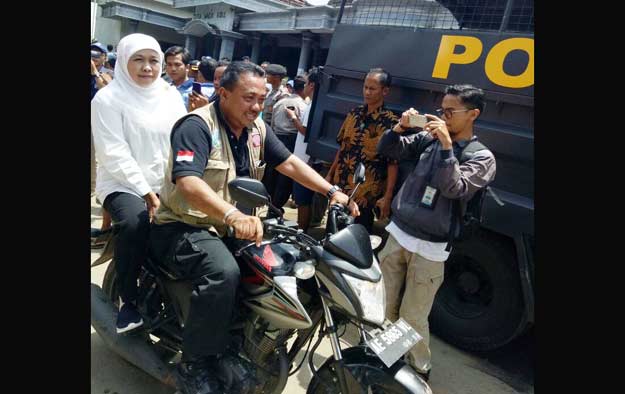 Menteri Sosial, Khofifah Indar Parawansa menumpang sepeda motor untuk menjangkau lokasi longsor yang tidak bisa dilewati kendaraan roda empat.