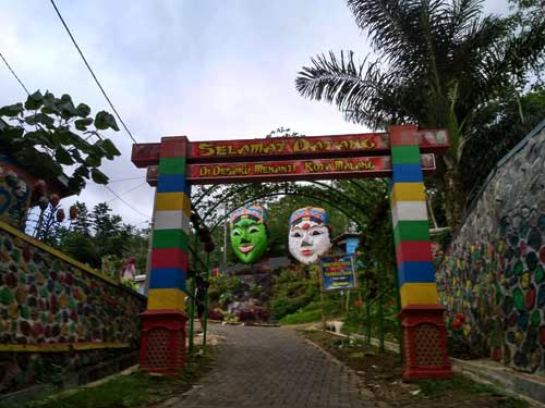 Masuk desa, langsung disapa topeng. foto: Retno A W/BANGSAONLINE